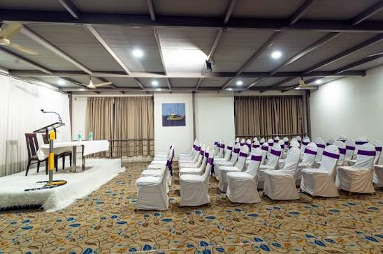 Banquet hall at Hotel Chaitali set for a seminar with a podium and stage