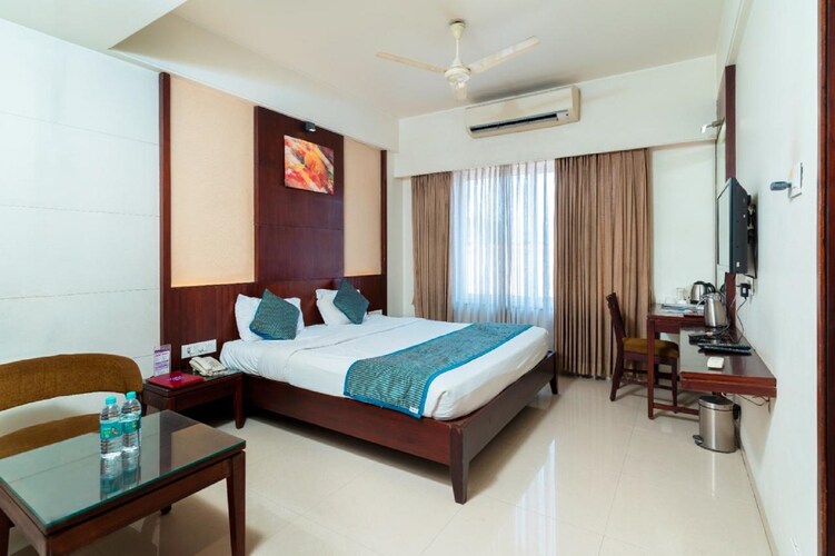 Deluxe A/C room at Hotel Chaitali with a made bed and seating