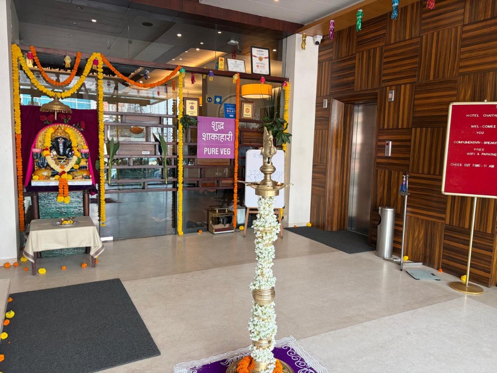 Hotel Chaitali lobby with Pure Veg sign, Ganesha shrine and guest entrance