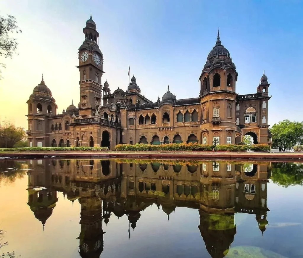 New Palace, Kolhapur, with clock tower, domes and reflection in the palace lake