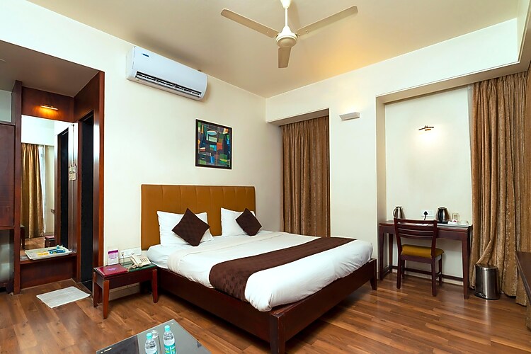 Super Deluxe room at Hotel Chaitali with a comfortable bed and warm interiors