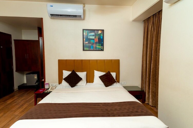 Super Deluxe room at Hotel Chaitali facing the bed and wardrobe